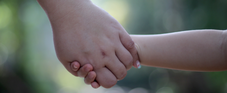 Mother holding her daughters hand to represent time-sharing responsibilities